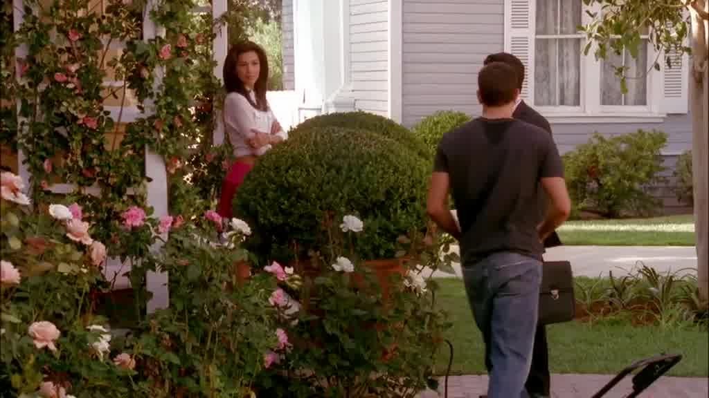 John walks between CARLOS and GABRIELLE, up the porch steps and into the house.jpg