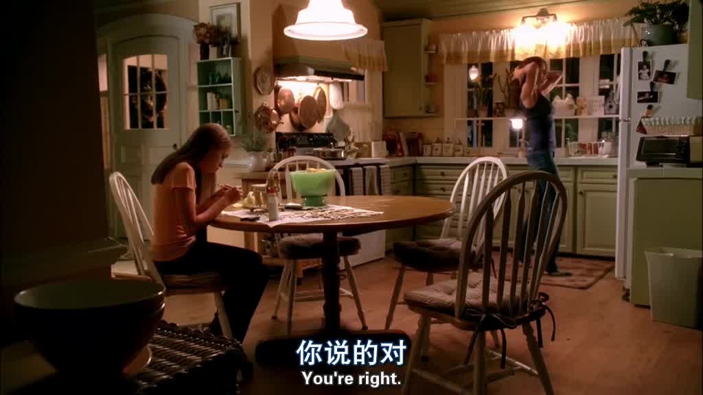 JULIE is sitting at the kitchen table, doing a school project of making a model .jpg
