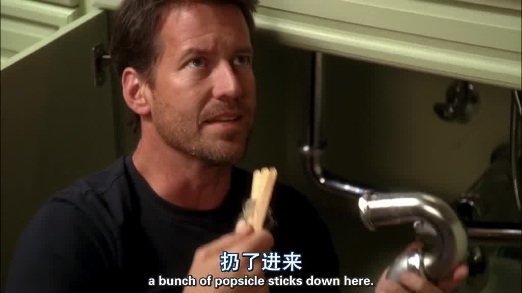 Mike takes a bunch of popsicle sticks out of a section of the pipes as he looks .jpg