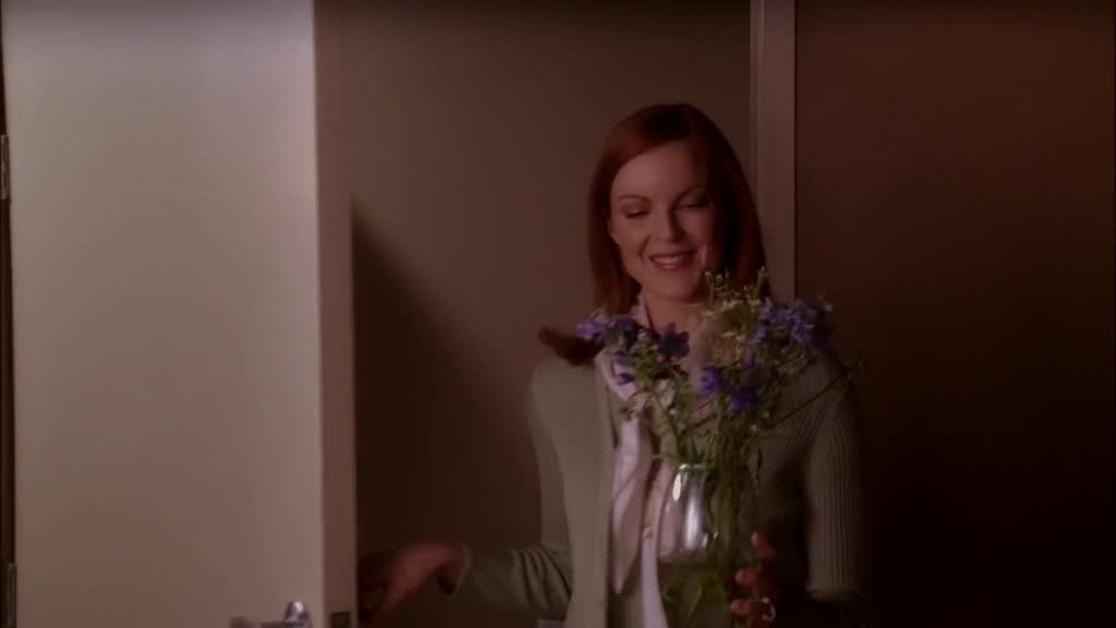 BREE walks out of the bathroom holding the vase, smiling serenely.jpg