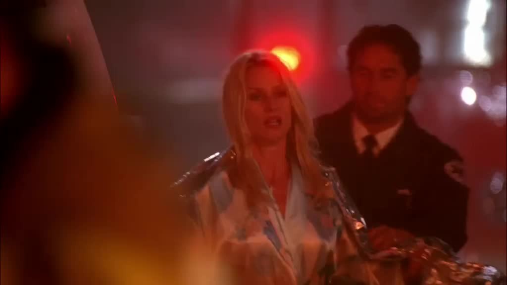 EDIE, wrapped in a blanket and followed by a fireman, rushes out from behind a f.jpg