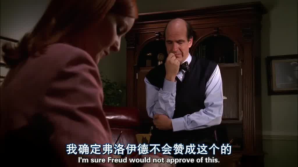 DR. GOLDFINE is leaning against his desk, watching as BREE sews his button back on.jpg