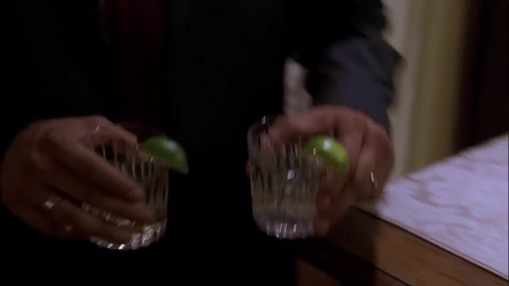 Carlos gives Mama Solis, who's sitting on the couch, a drink.jpg