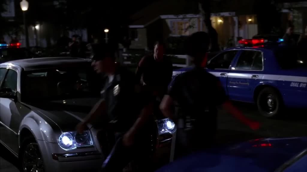 There are police cars and flashing lights everywhere, when Bree and Rex arrive.jpg