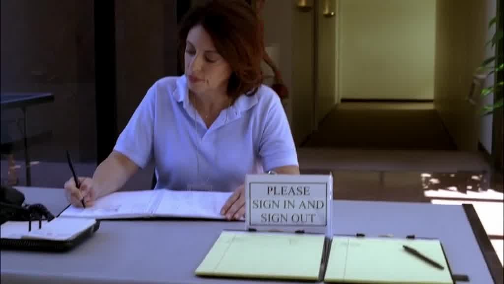 A nurse, sitting at a desk with her back to them, is working.jpg