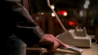 S01E01 MIKE pulls a gun out of his pocket, putting it down next to the phone
