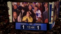 S01E04 Chandler and Joey hold the puck and wave at the TV thing