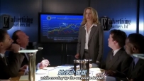S01E01 a room full of corporate business people taking notes or watching as she shows her presentation, smiling with confidence