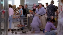 S01E01 A cart comes out of an aisle behind LYNETTE and bumps into an elderly lady, who gasps and falls over
