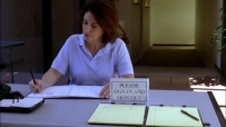 S01E06 A nurse, sitting at a desk with her back to them, is working